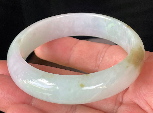 Close-up of fine crystalline texture and gentle lavender hues on icy milky white and green jadeite bangle