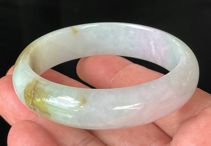 Close-up of fine crystalline texture and gentle lavender hues on icy milky white and green jadeite bangle