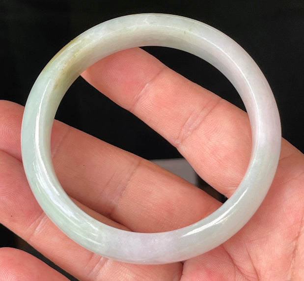 Close-up of fine crystalline texture and gentle lavender hues on icy milky white and green jadeite bangle