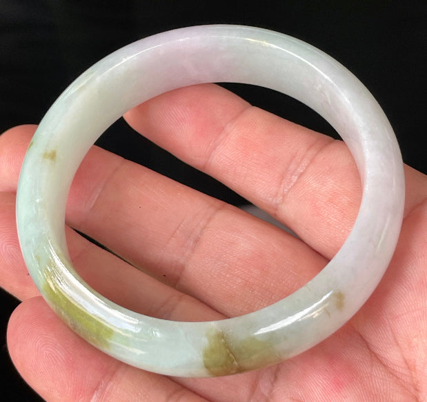 Close-up of fine crystalline texture and gentle lavender hues on icy milky white and green jadeite bangle