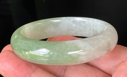 Close-up of fine crystalline texture and apple green hues on icy milky white jadeite bangle
