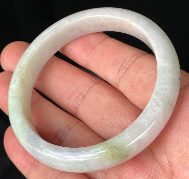 Close-up of fine crystalline texture and refreshing apple green hues on icy milky white jadeite bangle