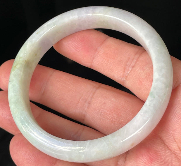 Close-up of fine crystalline texture and refreshing apple green hues on icy milky white jadeite bangle