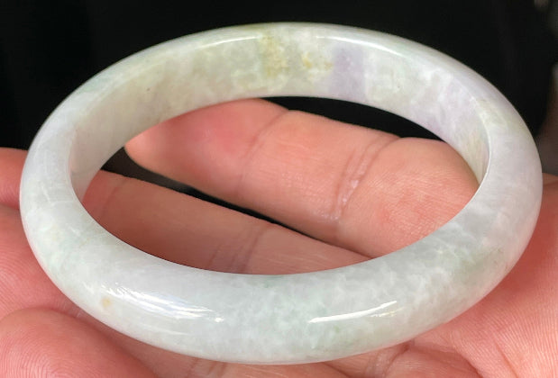 Close-up of fine crystalline texture and refreshing apple green hues on icy milky white jadeite bangle