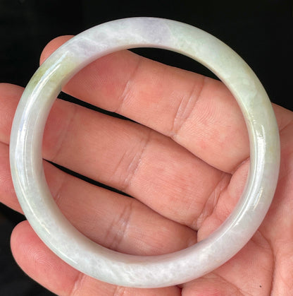 Close-up of fine crystalline texture and refreshing apple green hues on icy milky white jadeite bangle