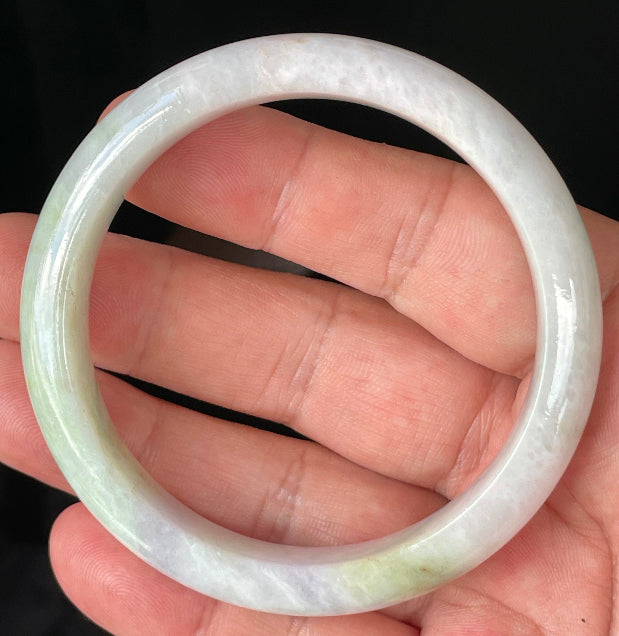 Close-up of fine crystalline texture and refreshing apple green hues on icy milky white jadeite bangle