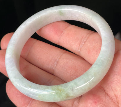Close-up of fine crystalline texture and refreshing apple green hues on icy milky white jadeite bangle