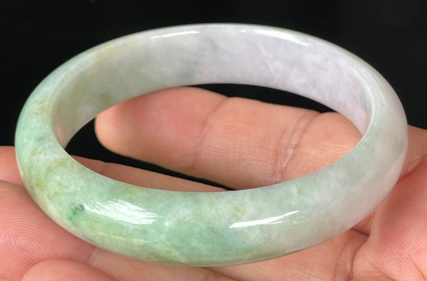 Close-up of fine crystalline texture and rich imperial green swirls on icy light lavender jadeite bangle