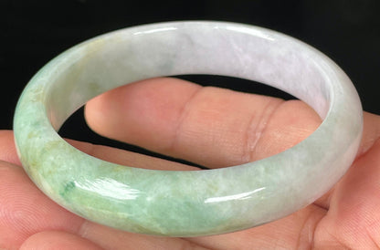 Close-up of fine crystalline texture and rich imperial green swirls on icy light lavender jadeite bangle