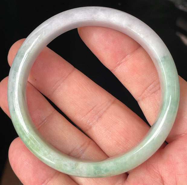 Close-up of fine crystalline texture and rich imperial green swirls on icy light lavender jadeite bangle