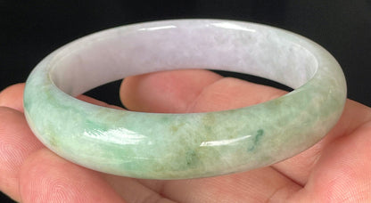 Close-up of fine crystalline texture and rich imperial green swirls on icy light lavender jadeite bangle