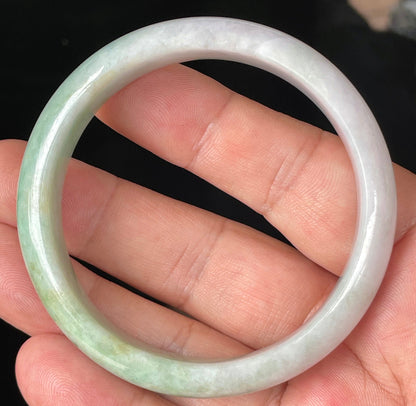 Close-up of fine crystalline texture and rich imperial green swirls on icy light lavender jadeite bangle