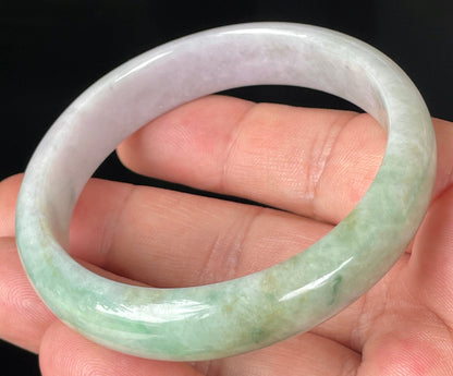 Close-up of fine crystalline texture and rich imperial green swirls on icy light lavender jadeite bangle