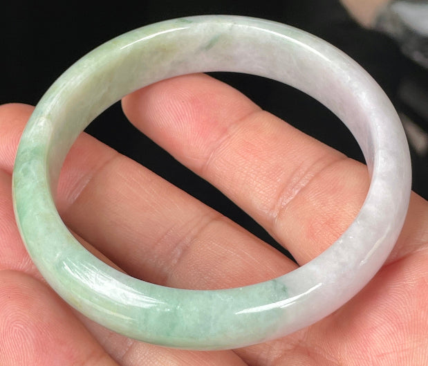 Close-up of fine crystalline texture and rich imperial green swirls on icy light lavender jadeite bangle