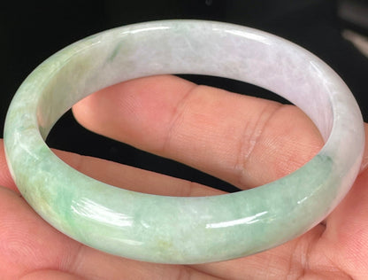 Close-up of fine crystalline texture and rich imperial green swirls on icy light lavender jadeite bangle