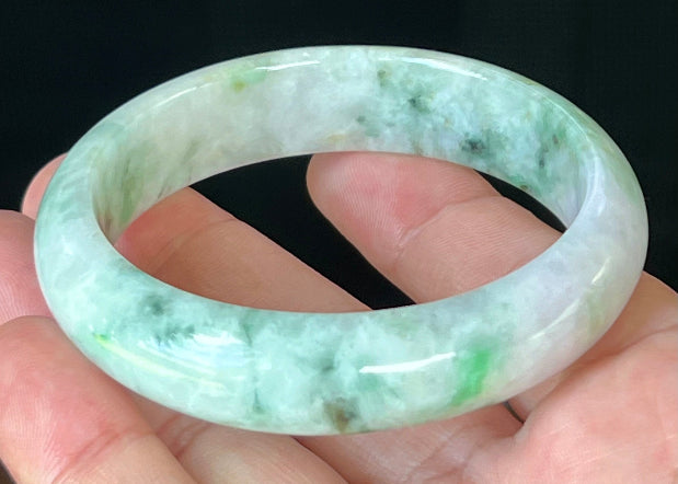 Close-up of fine crystalline texture and imperial green patterns on icy white and lavender jadeite bangle