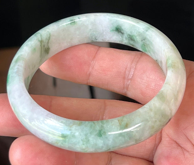 Close-up of fine crystalline texture and imperial green patterns on icy white and lavender jadeite bangle
