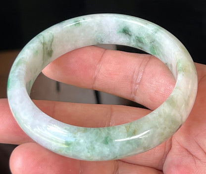 Close-up of fine crystalline texture and imperial green patterns on icy white and lavender jadeite bangle
