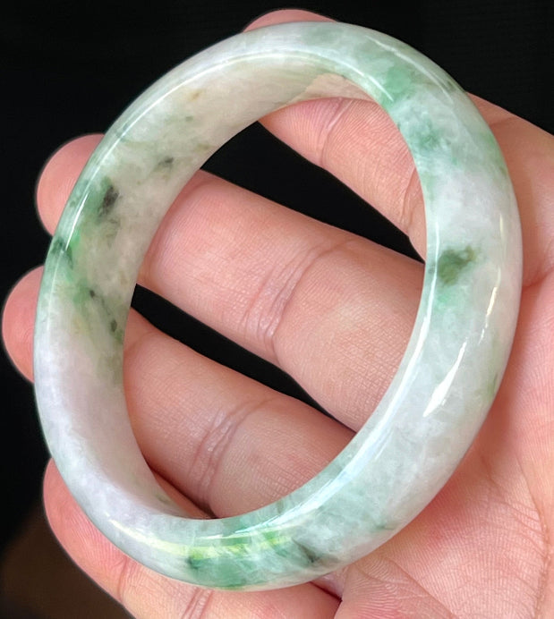 Close-up of fine crystalline texture and imperial green patterns on icy white and lavender jadeite bangle