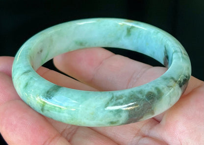 Close-up of fine crystalline texture and honey tones on icy forest green jadeite bangle