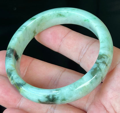 Close-up of fine crystalline texture and honey tones on icy forest green jadeite bangle