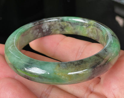 Close-up of fine crystalline texture and deep black patterns on icy imperial green jadeite bangle