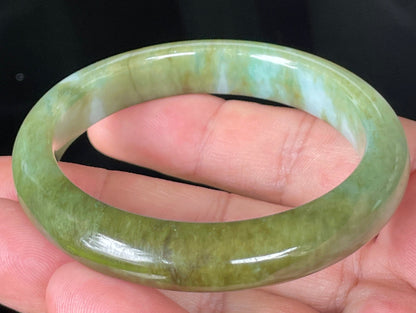 Close-up of fine crystalline texture and subtle bluish tones on icy forest green jadeite bangle