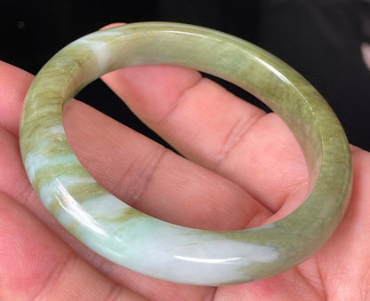 Close-up of fine crystalline texture and subtle bluish tones on icy forest green jadeite bangle