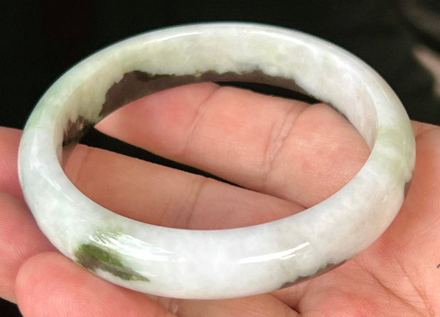 Close-up of fine crystalline texture and lush forest green patterns on icy milky white jadeite bangle