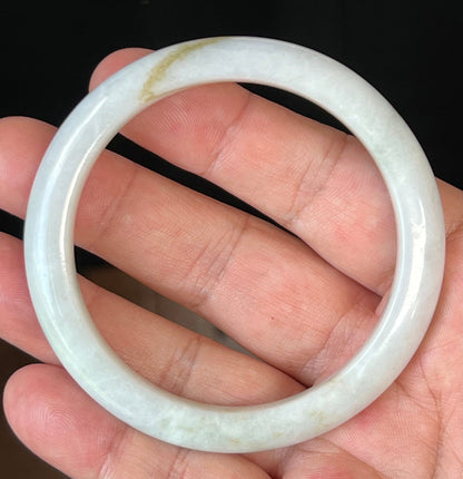 Close-up of fine crystalline texture and forest green hues on icy milky white jadeite bangle
