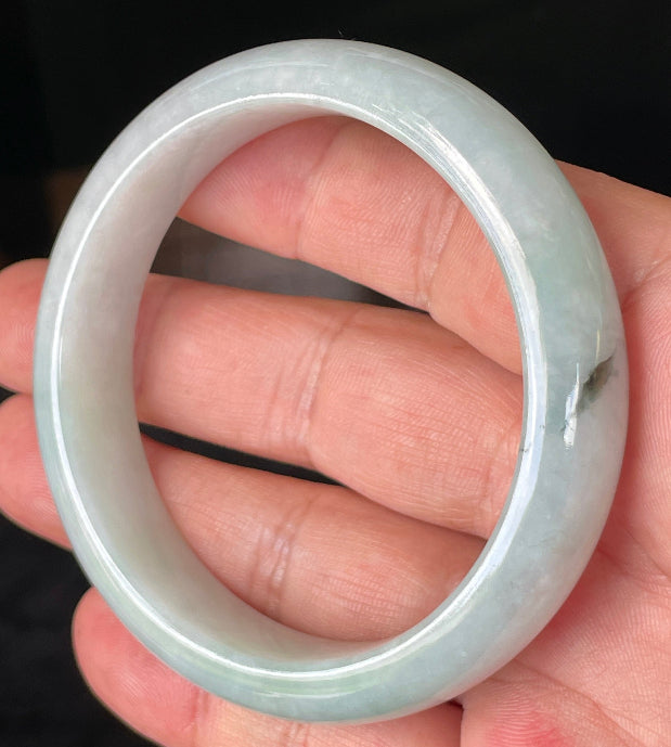 Close-up of fine crystalline texture and gentle green-blue tones on icy greyish white jadeite bangle