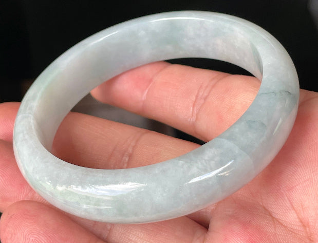 Close-up of fine crystalline texture and gentle green-blue tones on icy greyish white jadeite bangle