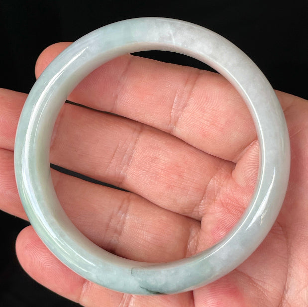 Close-up of fine crystalline texture and gentle green-blue tones on icy greyish white jadeite bangle