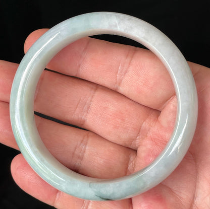 Close-up of fine crystalline texture and gentle green-blue tones on icy greyish white jadeite bangle