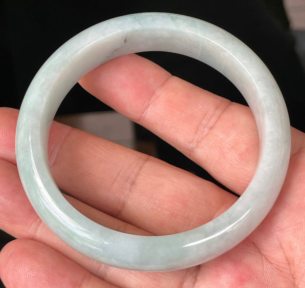 Close-up of fine crystalline texture and gentle green-blue tones on icy greyish white jadeite bangle