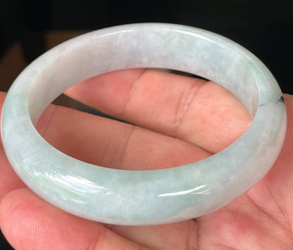 Close-up of fine crystalline texture and gentle green-blue tones on icy greyish white jadeite bangle