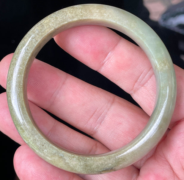 Close-up of fine crystalline texture and soothing green hues on icy milky white jadeite bangle
