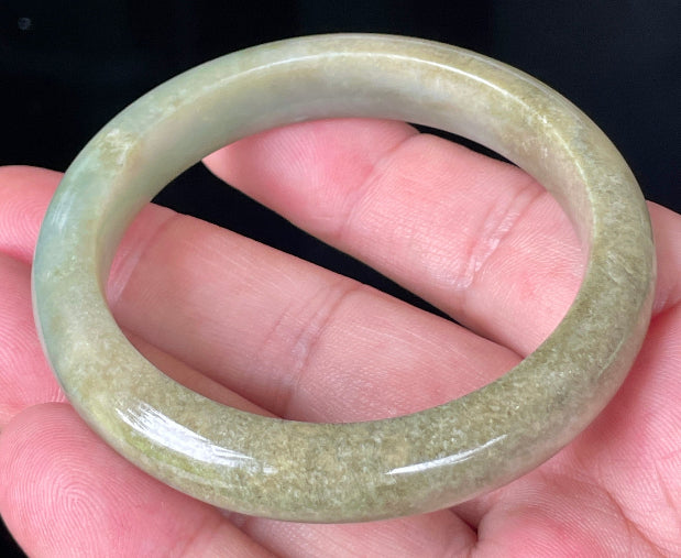 Close-up of fine crystalline texture and soothing green hues on icy milky white jadeite bangle