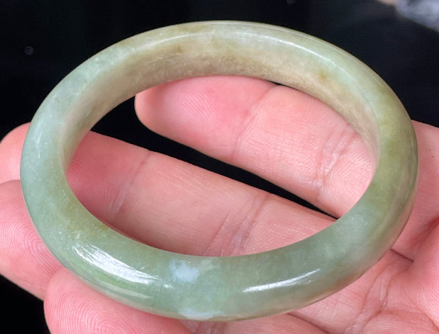 Close-up of fine crystalline texture and soothing green hues on icy milky white jadeite bangle