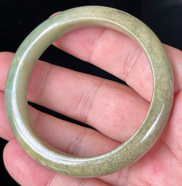 Close-up of fine crystalline texture and soothing green hues on icy milky white jadeite bangle