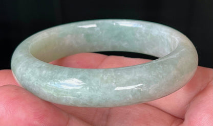Close-up of fine crystalline texture and milky white tones on icy apple green jadeite bangle
