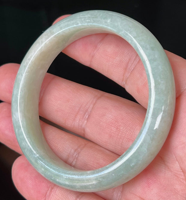 Close-up of fine crystalline texture and milky white tones on icy apple green jadeite bangle