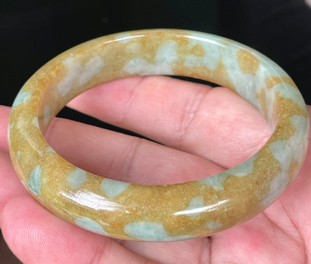 Close-up of fine crystalline texture and warm golden brown hues on icy honey jadeite bangle