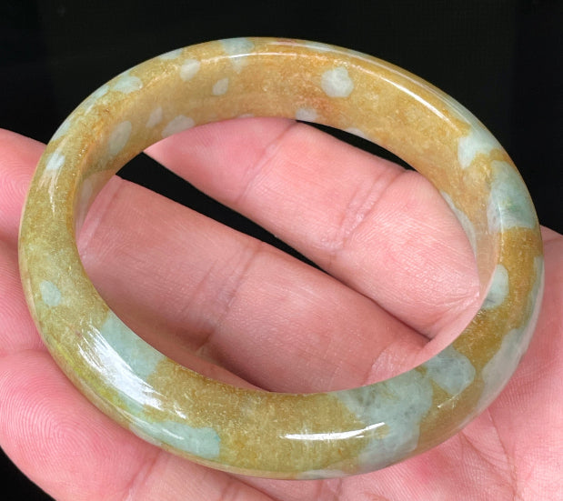 Close-up of fine crystalline texture and warm golden brown hues on icy honey jadeite bangle