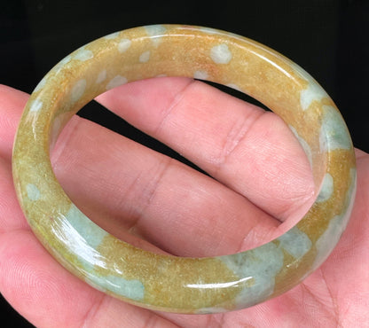 Close-up of fine crystalline texture and warm golden brown hues on icy honey jadeite bangle