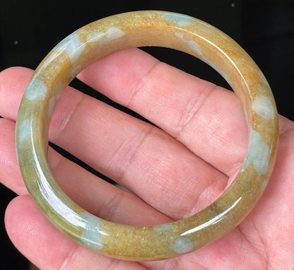 Close-up of fine crystalline texture and warm honey brown tones on bluish milky white jadeite bangle