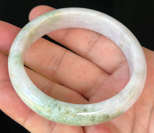 Close-up of fine crystalline texture and forest green streaks on icy milky white jadeite bangle