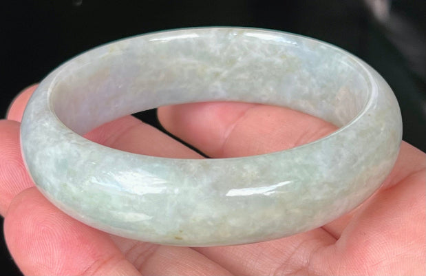 Close-up of fine crystalline texture and greyish hues on icy apple green jadeite bangle