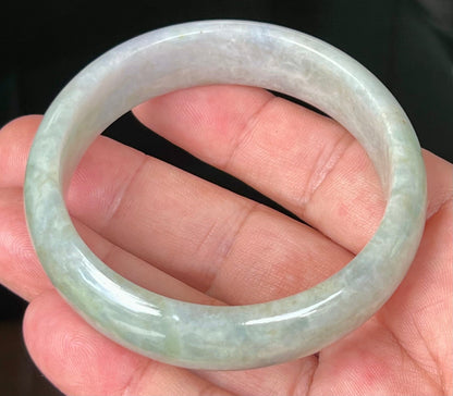 Close-up of fine crystalline texture and greyish hues on icy apple green jadeite bangle