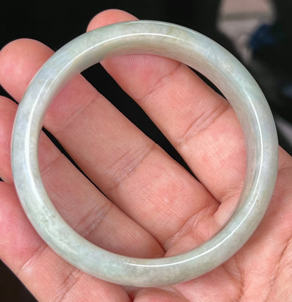 Close-up of fine crystalline texture and greyish hues on icy apple green jadeite bangle